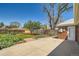 Spacious backyard boasting a concrete patio, landscaped garden beds, and a wooden fence at 5703 Ammons St, Arvada, CO 80002