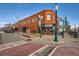 Brick building at a street corner with storefronts, streetlights, and signage at 5703 Ammons St, Arvada, CO 80002