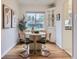Bright dining area with modern chairs, natural light, and a built-in cabinet for storage at 5703 Ammons St, Arvada, CO 80002