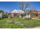 Classic brick home featuring a well-kept lawn, inviting porch, and mature trees in the yard at 5703 Ammons St, Arvada, CO 80002