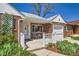 Inviting brick home showcasing a quaint front porch with outdoor seating and garden at 5703 Ammons St, Arvada, CO 80002