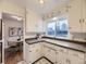Well-lit kitchen featuring white cabinetry, tile flooring, and a view into the dining area at 5703 Ammons St, Arvada, CO 80002
