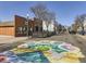 Street view featuring colorful ground art, commercial buildings, and pedestrian-friendly design at 5703 Ammons St, Arvada, CO 80002