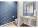 Stylish powder room with patterned wallpaper, unique sink, and modern fixtures at 8142 S Langdale Way, Aurora, CO 80016