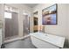 Modern bathroom featuring a sleek soaking tub and a separate tiled shower at 8142 S Langdale Way, Aurora, CO 80016