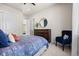 Comfortable bedroom with a blue patterned bedspread, dresser, and accent chair at 8142 S Langdale Way, Aurora, CO 80016