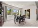 Bright dining area featuring a modern table, ample seating, and natural light from large windows at 8142 S Langdale Way, Aurora, CO 80016