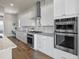 Modern kitchen with stainless steel appliances, white cabinetry, and a built-in desk area at 8142 S Langdale Way, Aurora, CO 80016