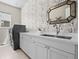 Well-lit laundry room featuring modern washer/dryer units and birch tree wallpaper at 8142 S Langdale Way, Aurora, CO 80016