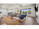 Spacious living room with fireplace, large windows, and seamless flow to the adjacent kitchen and dining area at 8142 S Langdale Way, Aurora, CO 80016
