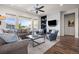 Elegant living room with large windows, a ceiling fan, and a cozy fireplace at 8142 S Langdale Way, Aurora, CO 80016
