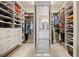 Spacious walk-in closet with custom shelving and mirrored door at 8142 S Langdale Way, Aurora, CO 80016