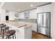 Modern wet bar featuring white cabinets, stainless steel appliances, and ample counter space for entertaining at 8142 S Langdale Way, Aurora, CO 80016
