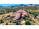 Stunning aerial view of unique rock formations and surrounding landscape with trees and open fields at 5799 Crestbrook Cir, Morrison, CO 80465