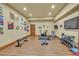 Spacious home gym with workout equipment, including weights and a TV at 1423 E Fair Pl, Centennial, CO 80121