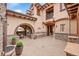 Outdoor living space featuring a stucco exterior, stone accents, a stone bench and an arched alcove with chairs at 1423 E Fair Pl, Centennial, CO 80121