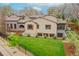 Lush backyard featuring a well-manicured lawn, mature trees, and an elegant stone and stucco home exterior at 1423 E Fair Pl, Centennial, CO 80121