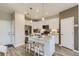 Modern kitchen with white cabinets, granite island, stainless steel appliances, and hardwood floors at 6932 Huddersfield Ln, Castle Pines, CO 80108