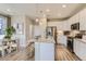 Modern kitchen with white cabinets, granite island, stainless steel appliances, and hardwood floors at 6932 Huddersfield Ln, Castle Pines, CO 80108