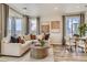 Bright and airy living room with sectional sofa, coffee table, and dining area at 6932 Huddersfield Ln, Castle Pines, CO 80108