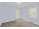 Comfortable bedroom with neutral carpet, a window with blinds, and a glass paneled door at 1273 S Jackson St, Denver, CO 80210