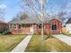 Charming red brick single-story home with sidewalk and bare trees in the yard at 1273 S Jackson St, Denver, CO 80210