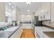 Bright kitchen with white cabinetry, stainless steel appliances, and hardwood flooring at 1273 S Jackson St, Denver, CO 80210