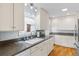 Well-lit kitchen featuring white cabinets, granite countertops, and stainless steel appliances at 1273 S Jackson St, Denver, CO 80210