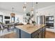 Open-concept kitchen and dining area with a large center island, stainless steel appliances, and modern finishes at 5210 Gray Wolf Ln, Castle Rock, CO 80104