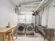 A utility basement features a washer, dryer, utility sink, ironing board and limited storage space at 724 N Franklin St, Denver, CO 80218