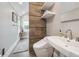Bathroom with modern toilet and sink, and a towel rack on brown tiled accent wall at 724 N Franklin St, Denver, CO 80218