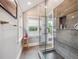 Bright bathroom with a glass shower, gray tile, and natural light streaming through the window at 724 N Franklin St, Denver, CO 80218