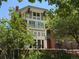 A charming home exterior showcases multi-story architecture with trees, lush landscaping and a brick retaining wall at 724 N Franklin St, Denver, CO 80218
