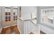 Hallway with a white banister, wood floors, and glass paned doors leading into a bedroom at 724 N Franklin St, Denver, CO 80218