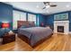 Spacious main bedroom featuring hardwood floors, a king bed, fireplace, and blue accent walls at 724 N Franklin St, Denver, CO 80218