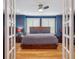 View through french doors into a main bedroom with blue walls, hardwood floors, and a king size bed at 724 N Franklin St, Denver, CO 80218