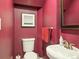 Compact powder room with stylish vanity and a modern toilet, featuring bright red walls and a decorative mirror at 724 N Franklin St, Denver, CO 80218