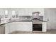 Clean kitchen featuring white cabinets, stainless steel appliances, and grey subway tile at 1225 S Xavier St, Denver, CO 80219