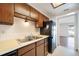Kitchen area featuring wood cabinets, updated appliances, and double sink at 12113 Melody Dr # 304, Denver, CO 80234