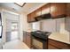 Kitchen featuring dark wood cabinets and black appliances at 12113 Melody Dr # 304, Denver, CO 80234
