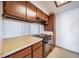 Well-lit kitchen with dark wood cabinets and white countertops, ready for cooking at 12113 Melody Dr # 304, Denver, CO 80234