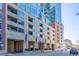 The exterior of the building features a beige stone facade, large windows, and well-maintained landscaping at 1700 Bassett St # 1321, Denver, CO 80202