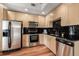 Well-lit kitchen features stainless steel appliances, black backsplash, and light wood cabinets at 1700 Bassett St # 1321, Denver, CO 80202