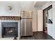 A stainless steel refrigerator next to the fireplace with black and white tiling at 1830 Newland Ct # 321, Lakewood, CO 80214