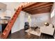 Living room with ladder access to loft, couch, and television, adjacent to kitchen and bathroom entrance at 1830 Newland Ct # 321, Lakewood, CO 80214