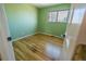 Bright bedroom with green walls, hardwood floors, and a window at 4328 S Carr Ct, Littleton, CO 80123