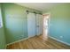 Cozy bedroom with light green walls, sliding barn doors, and wood floors, creating a relaxing space at 4328 S Carr Ct, Littleton, CO 80123