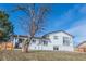 Charming home with white brick exterior, dark trim, a large yard and mature trees at 4328 S Carr Ct, Littleton, CO 80123