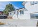 White brick home boasts large windows, inviting entrance, and an expansive concrete patio at 4328 S Carr Ct, Littleton, CO 80123
