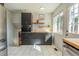 Modern kitchen features sleek black cabinets, stainless steel appliances, and white tile floors at 4328 S Carr Ct, Littleton, CO 80123